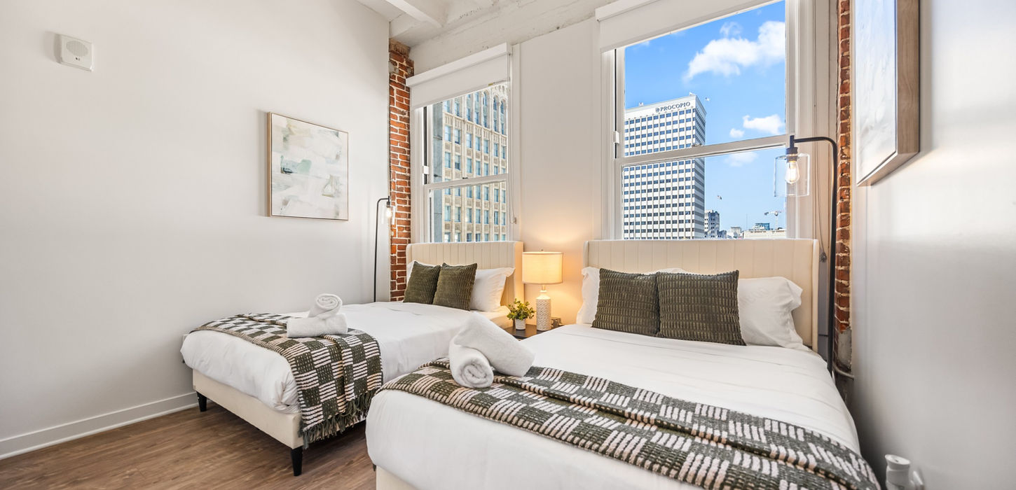 Two beds in bedroom with windows, furnished rentals, Celeste & Co.