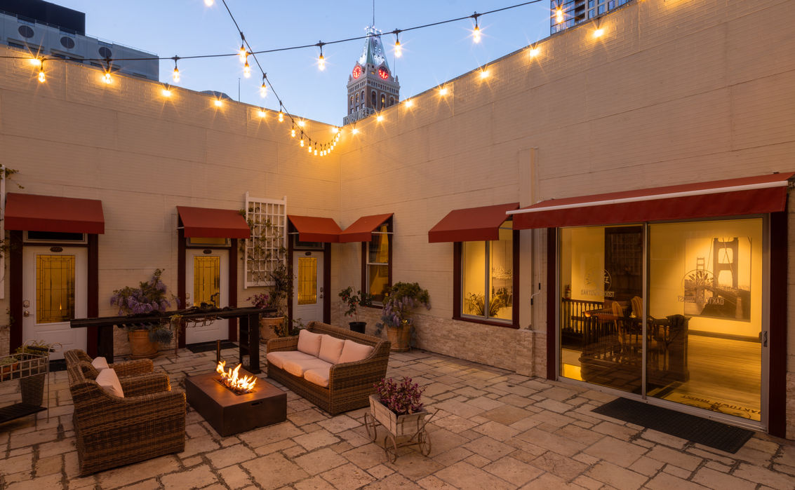 Hotel patio with string lights, fire pit, and outdoor seating