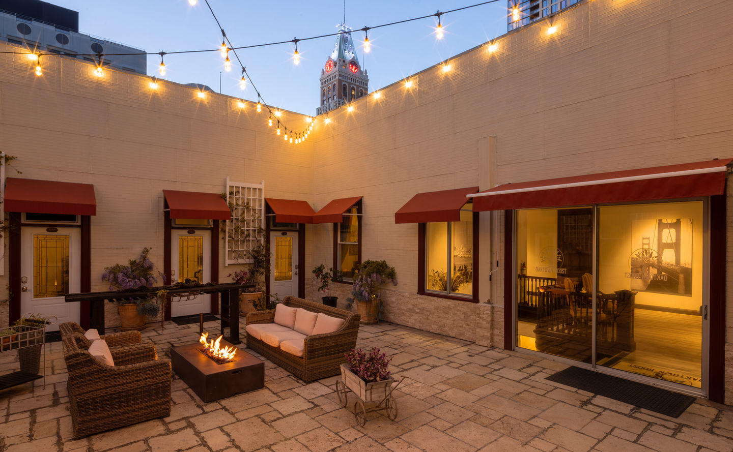 Hotel patio with string lights, fire pit, and outdoor seating