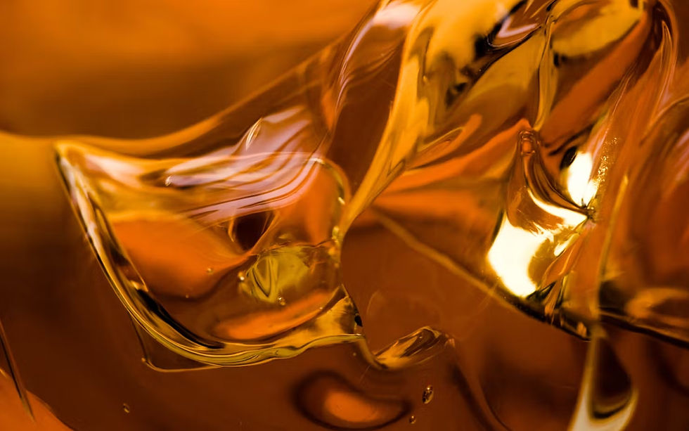 Abstract close-up of flowing amber liquid, showing reflective and glossy texture.