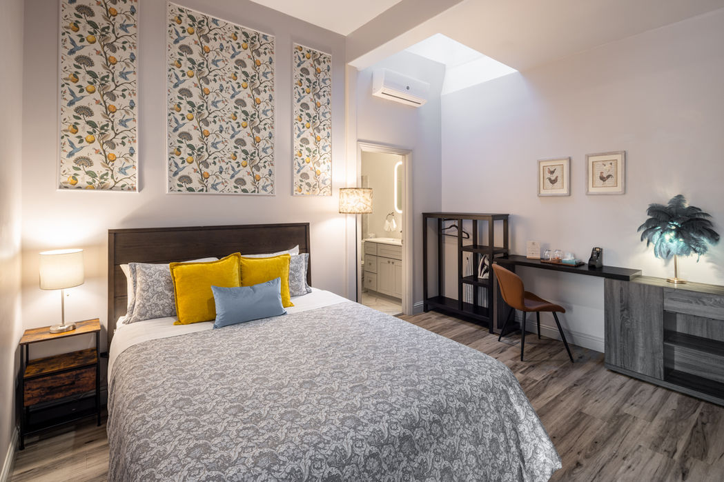 Hotel bedroom with bed, desk, and patterned wall