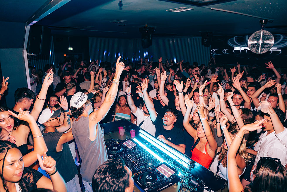 DJ performing for a large crowd at a nightclub