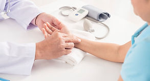 Medical Clinic doctor checking the pulse of a patient