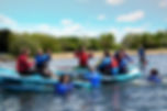 Group enjoying paddleboarding on sunny lake