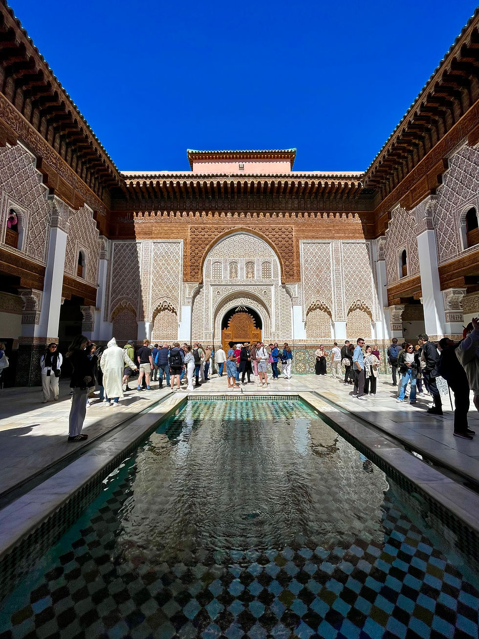 A riad courtyard with a pool and intricately designed walls and archways