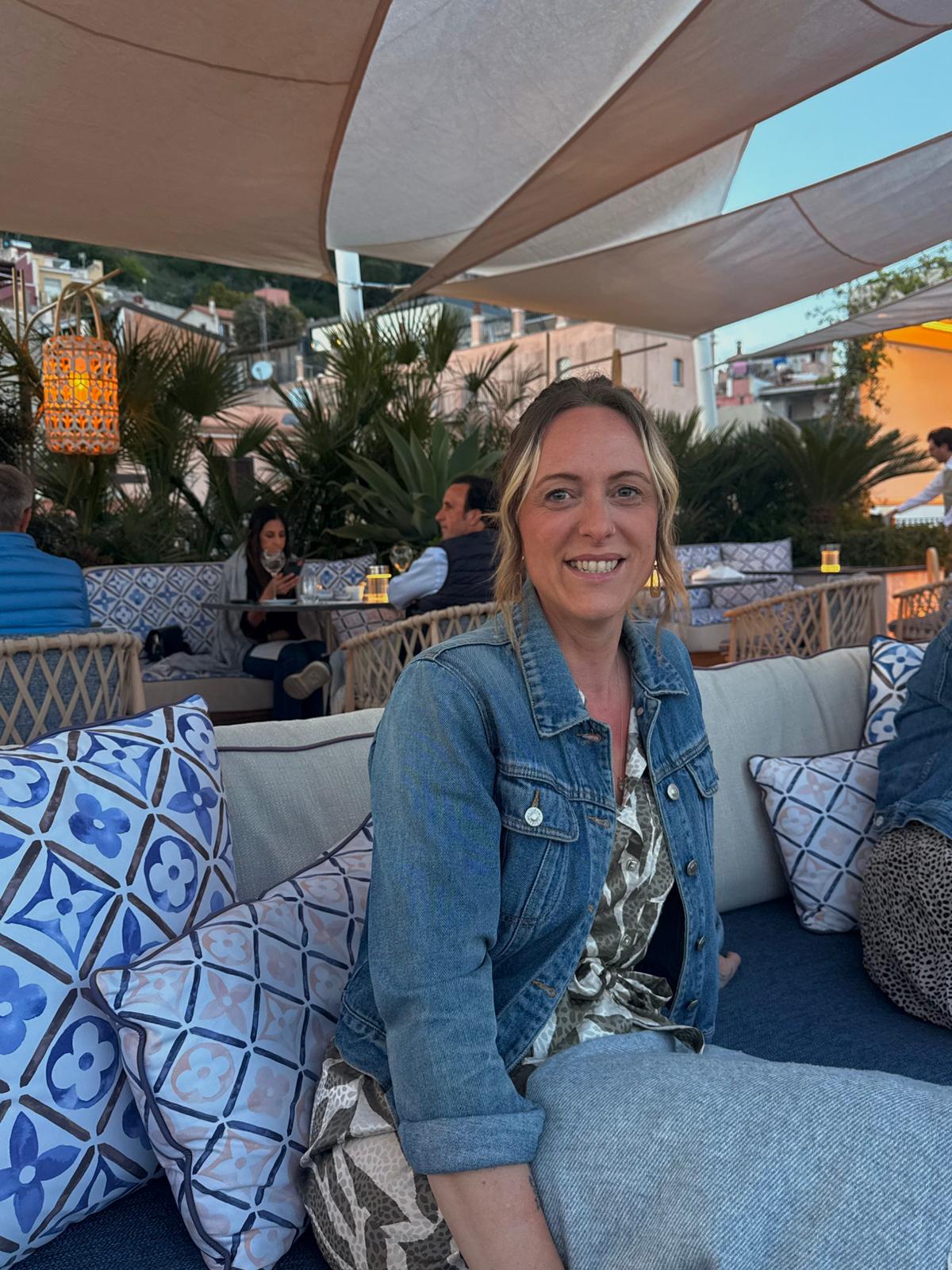 Smiling woman in denim jacket on outdoor patio