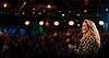 Woman speaker on stage addressing a large audience