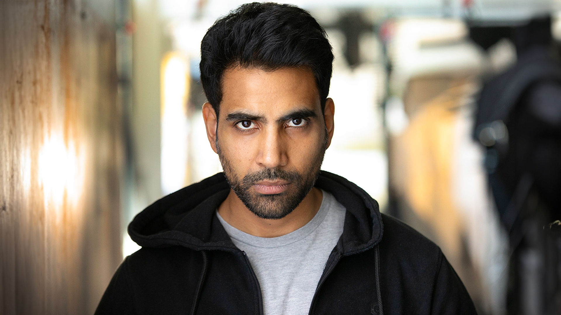Serious headshot of actor with ambient backdrop