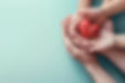 mains-adulte-enfant-tenant-coeur-rouge-fond-aqua_49149-908.jpg
