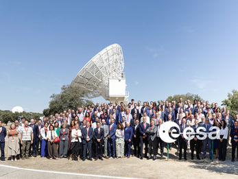 Gruppenfoto - vielen Menschen stehen vor einer großen Satellitenschüssel - rechts unten das esa logo