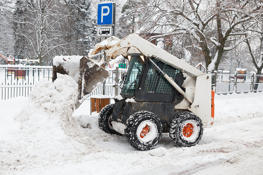 A bobcat skid steer removing snow