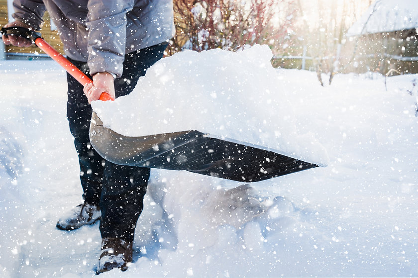 Man clearing snow with shovel during snow storm.