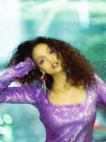 model looking at camera in sequined purple dress