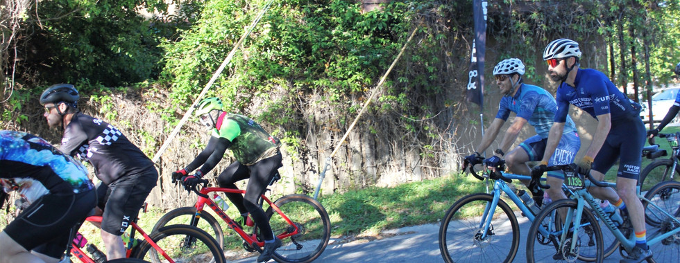 Chris smiles as he follows the police escort out to the start of the race with the other riders.