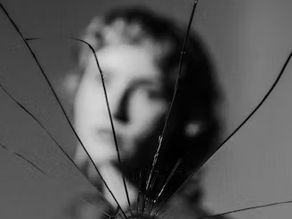 Person looking in a broken mirror. Self reflecting.