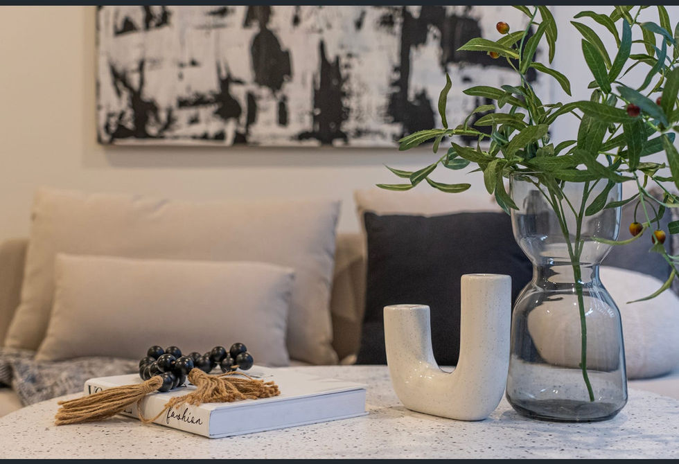 Modern decor with vase, book, and abstract art.