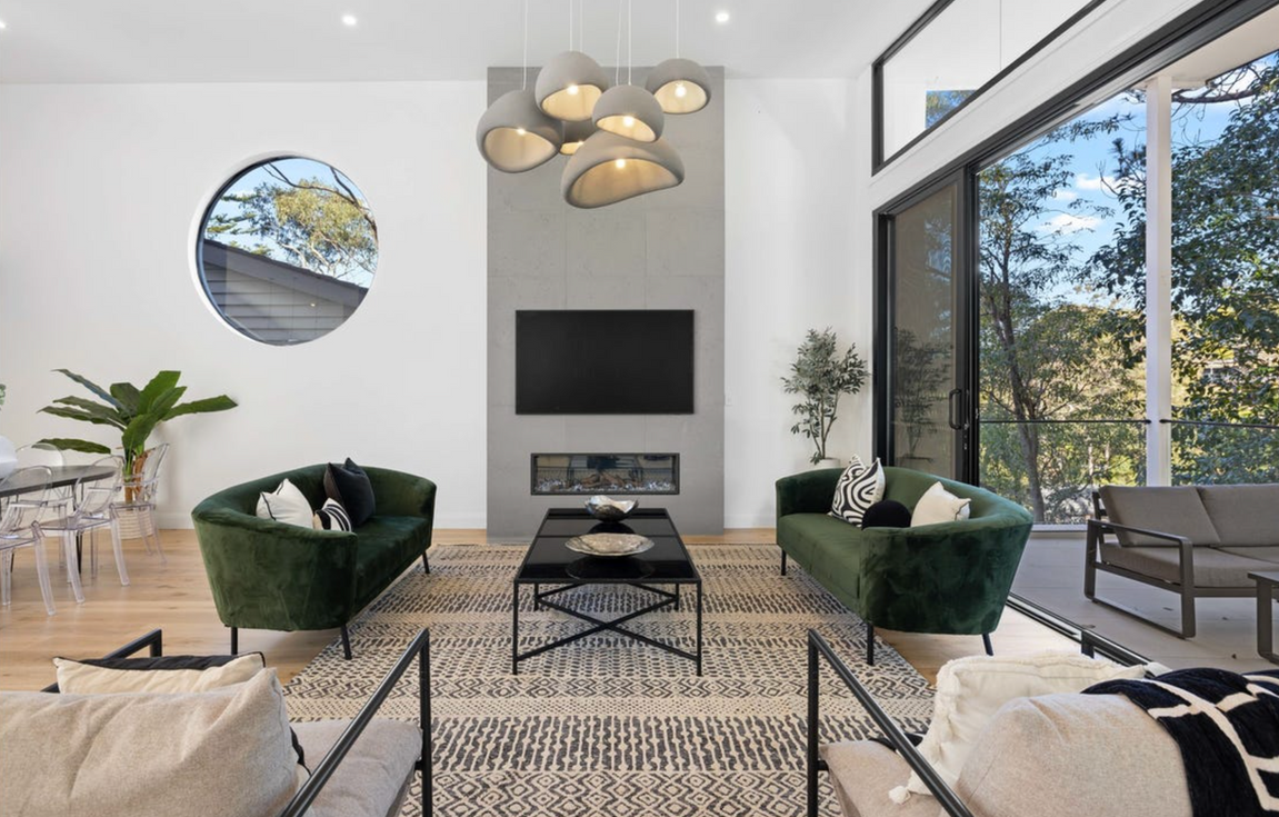 Luxury double-height living room with designer fireplace, modern styling and floor-to-ceiling windows