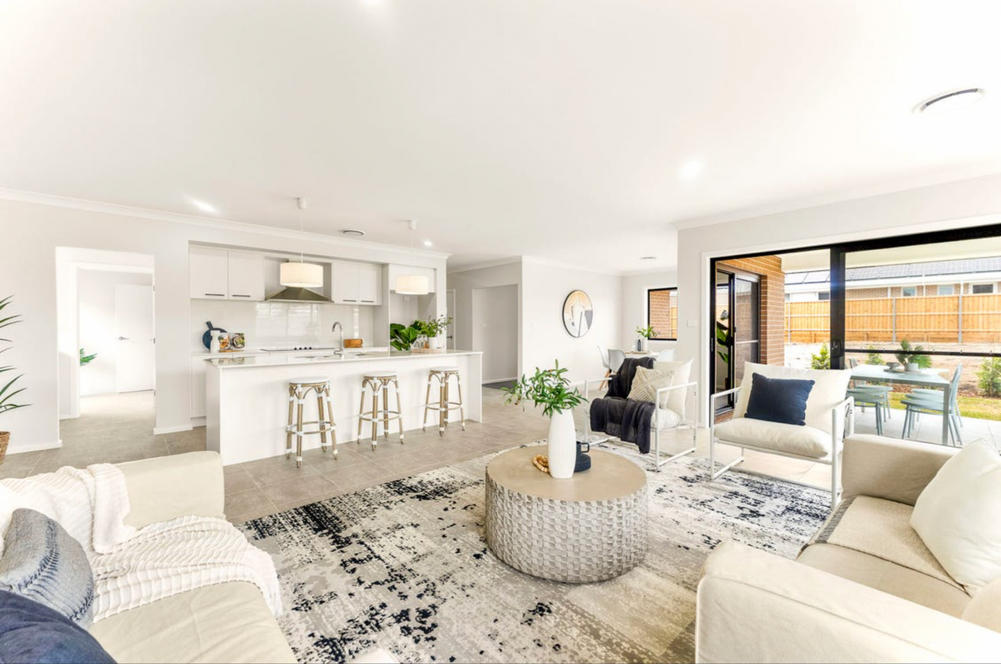 Modern open-plan living and kitchen area with contemporary styling and outdoor entertaining access