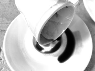 A cup of Greek Coffee tipped on its side in the saucer