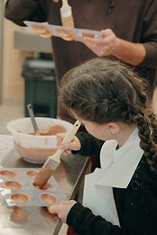Jeune fille préparant des madeleines au chocolat