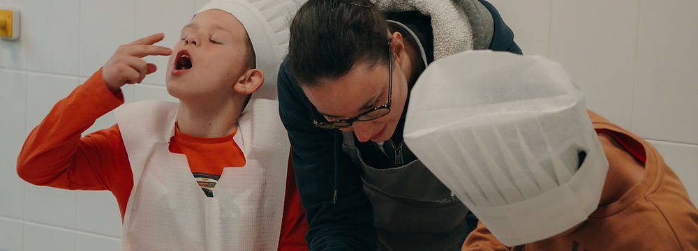 Deux enfants décorent des cupcakes lors d'un atelier pâtisserie.