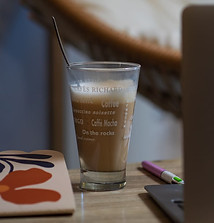 Café latté glacé sur un bureau à côté d'un ordinateur.
