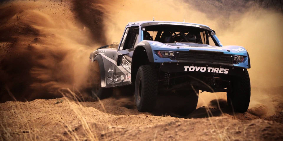 An offroad vehicle in a race in the desert