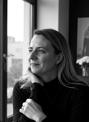 Portrait einer Frau in Businesskleidung mit Blick zur Seite – symbolisiert Entschlossenheit und Weitblick