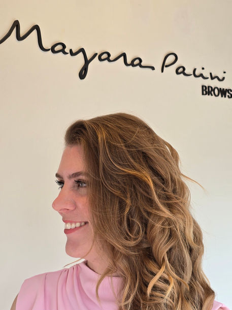 Mayara Pacini with Mayara Pacini Brows logo behind her