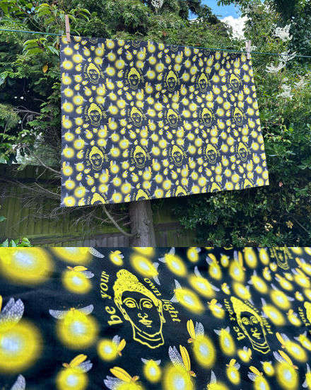 a black and yellow cloth with the words be your own light on it