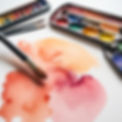Watercolor paint, paint brushes, and watercolor paper