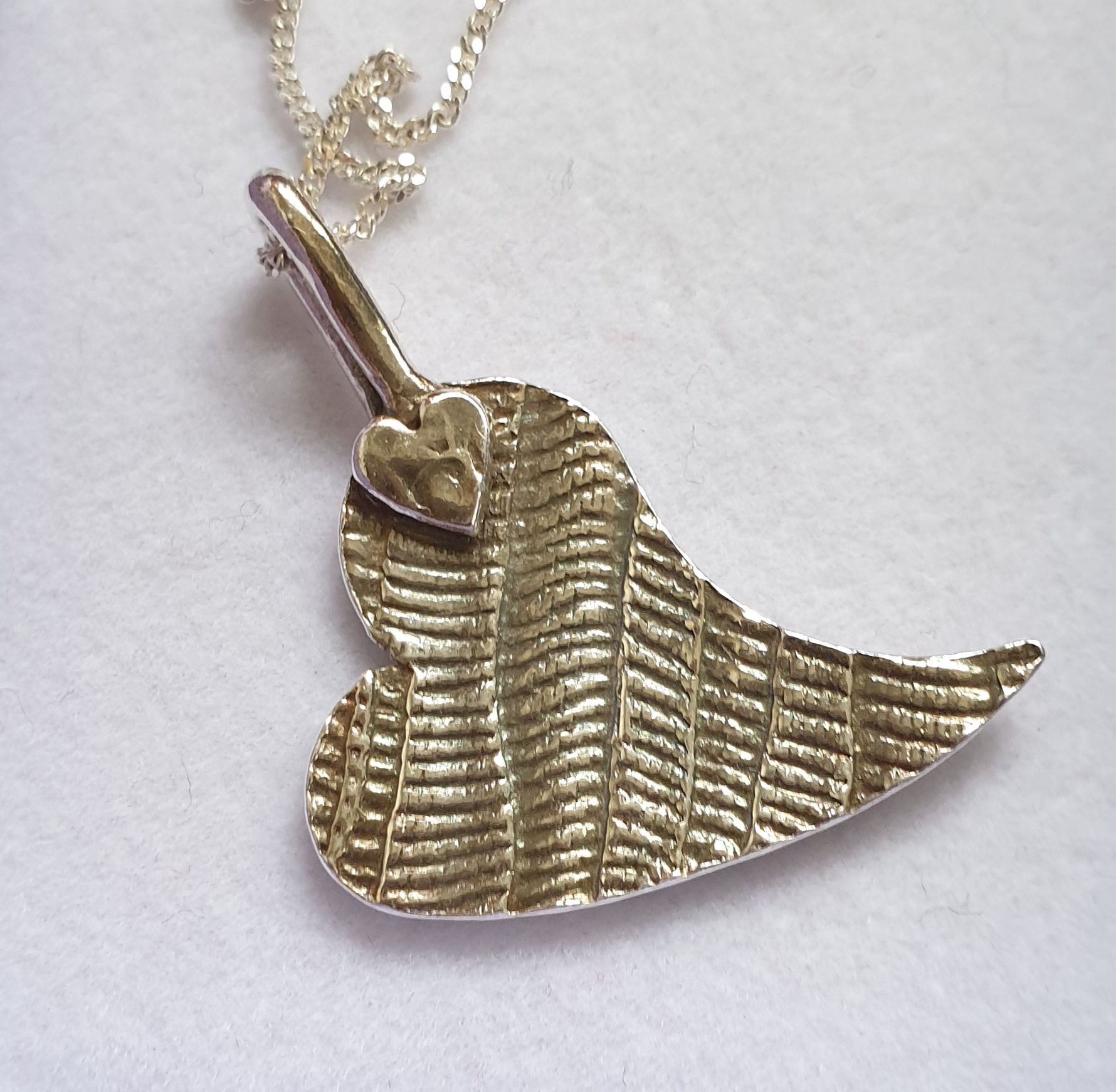 Silver patterned heart with small heart at bail