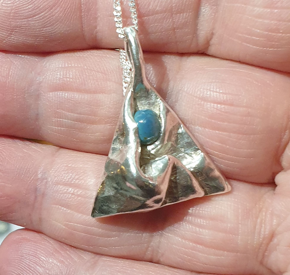Thumbnail: Silver triangle with folds and blue cabochon