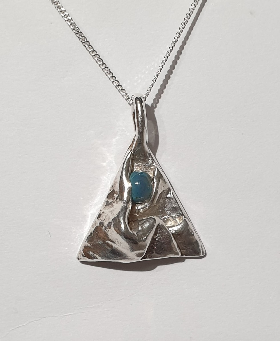 Thumbnail: Silver triangle with folds and blue cabochon