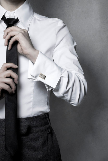 Luxury jewelry interpreted through fine art imagery and film. Fashionable female androgyne body wears cufflinks of platinum and gold.