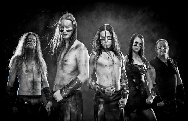 Ensiferum band posing with their ancient folk metal costumes and face masks on black and white studio shot. 