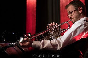 Jesse Baker playing his trumpet at a gig with Mixtape playing the horn charts that he arranged