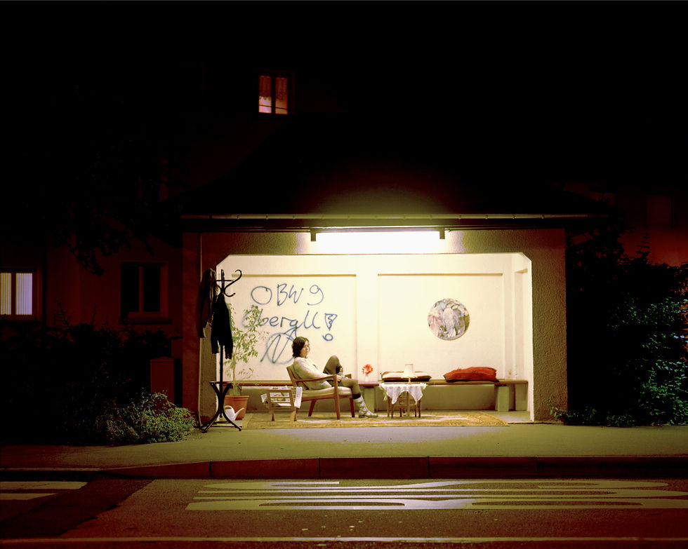 Thumbnail: Person sitting under bright light at night, possibly artwork by Taney Roniger