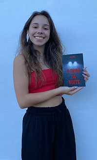 A photo of Rita Oliveira holding a copy of her first book