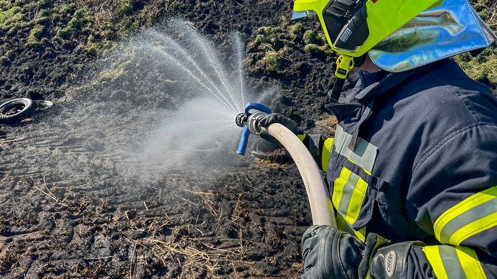 Ein Feuerwehrmensch in Uniform löscht