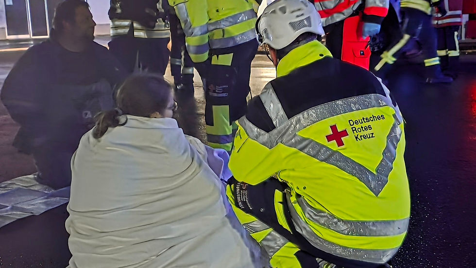 Feuerwehrmann und Mensch mit Decke von hinten