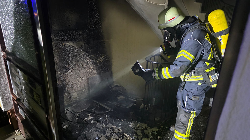 Feuerwehrmann spritzt Wasser in eine Ecke