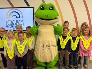 Sicher zur Schule: Übergabe reflektierender Warnüberwürfe an Erstklässler*innen