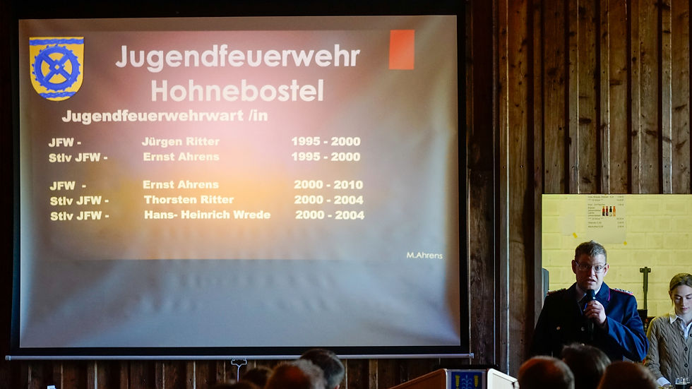 Mann am Mikro neben einer Projektionsfläche