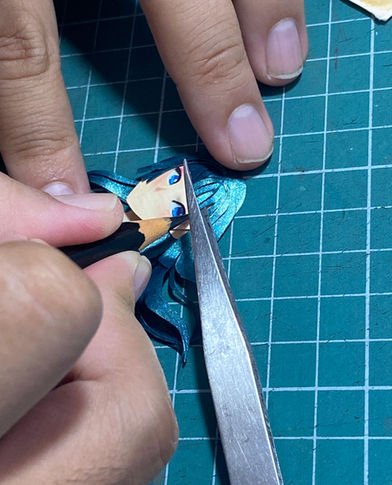 Mãos montando peça azul e preta com pinça.