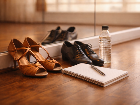 Dancesport shoes, water bottle and note book in a dance studio setting