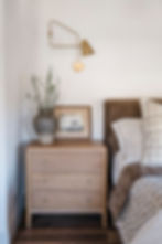 Gold accented sconce in primary bedroom.