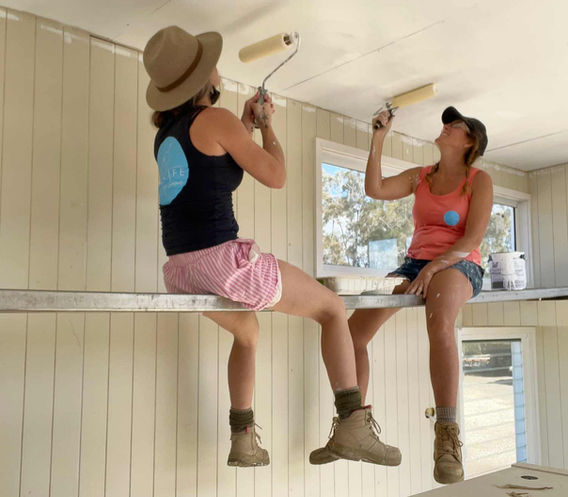 Interior Tiny House being built by Big Life Tiny Home with Bryh and Cris painting ceiling