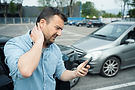 Man-holding-kneck-after-traffic-accident-shutterstock_2154839175.jpg
