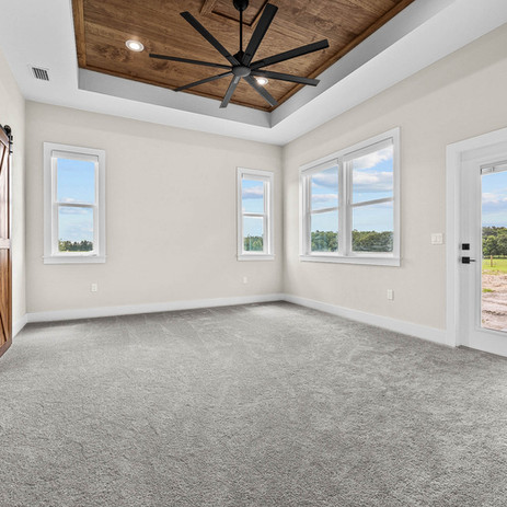 Bright empty interior bedroom, grey carpet, wooden ceiling fan, windows.
